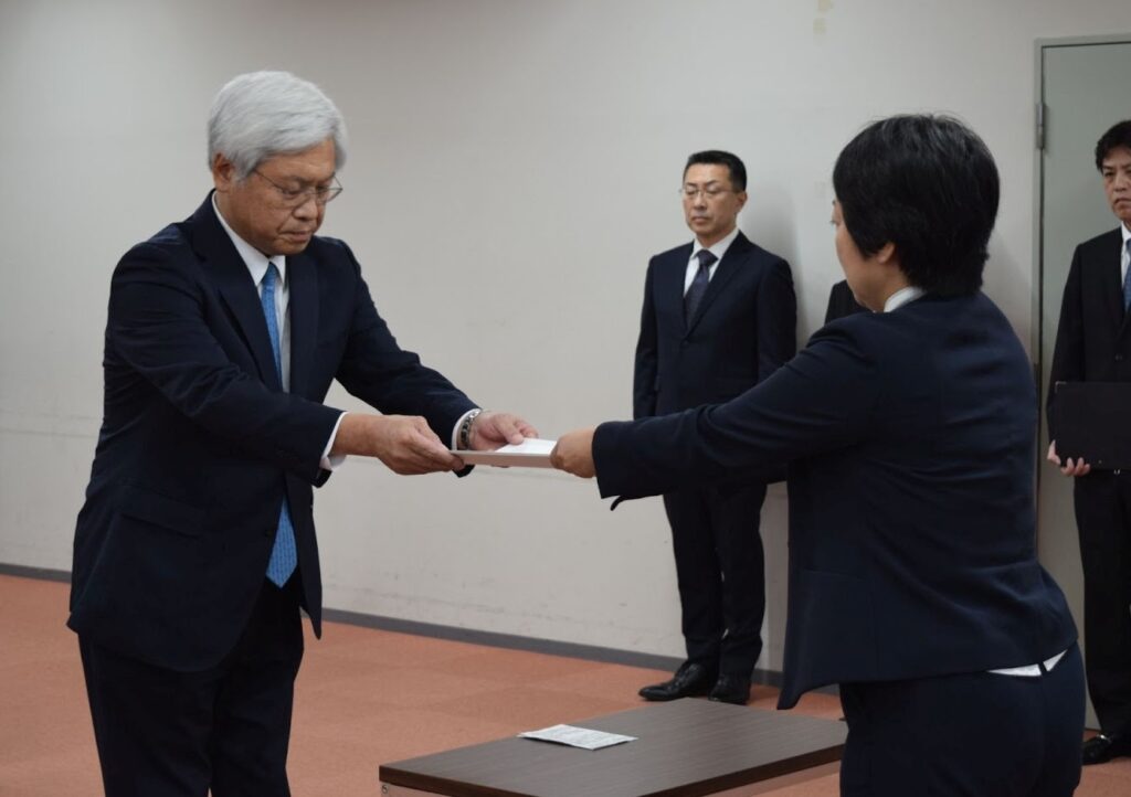 関運局の藤田局長㊨から通知書を受け取る日本郵便の千田社長
