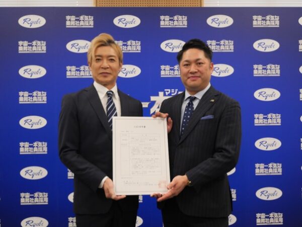 任命書を手にするつるのさん㊧と大上部門長