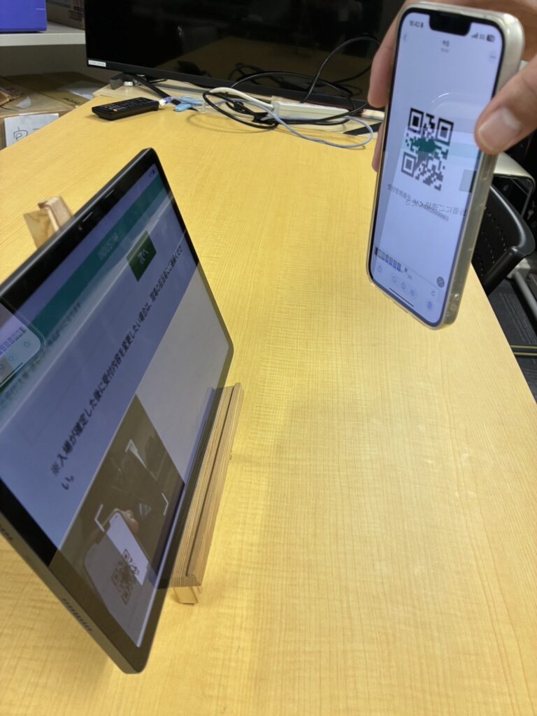 ドライバーのスマホに届いたQRコードをタブレットで読み込むことで受け付け手続きが完了